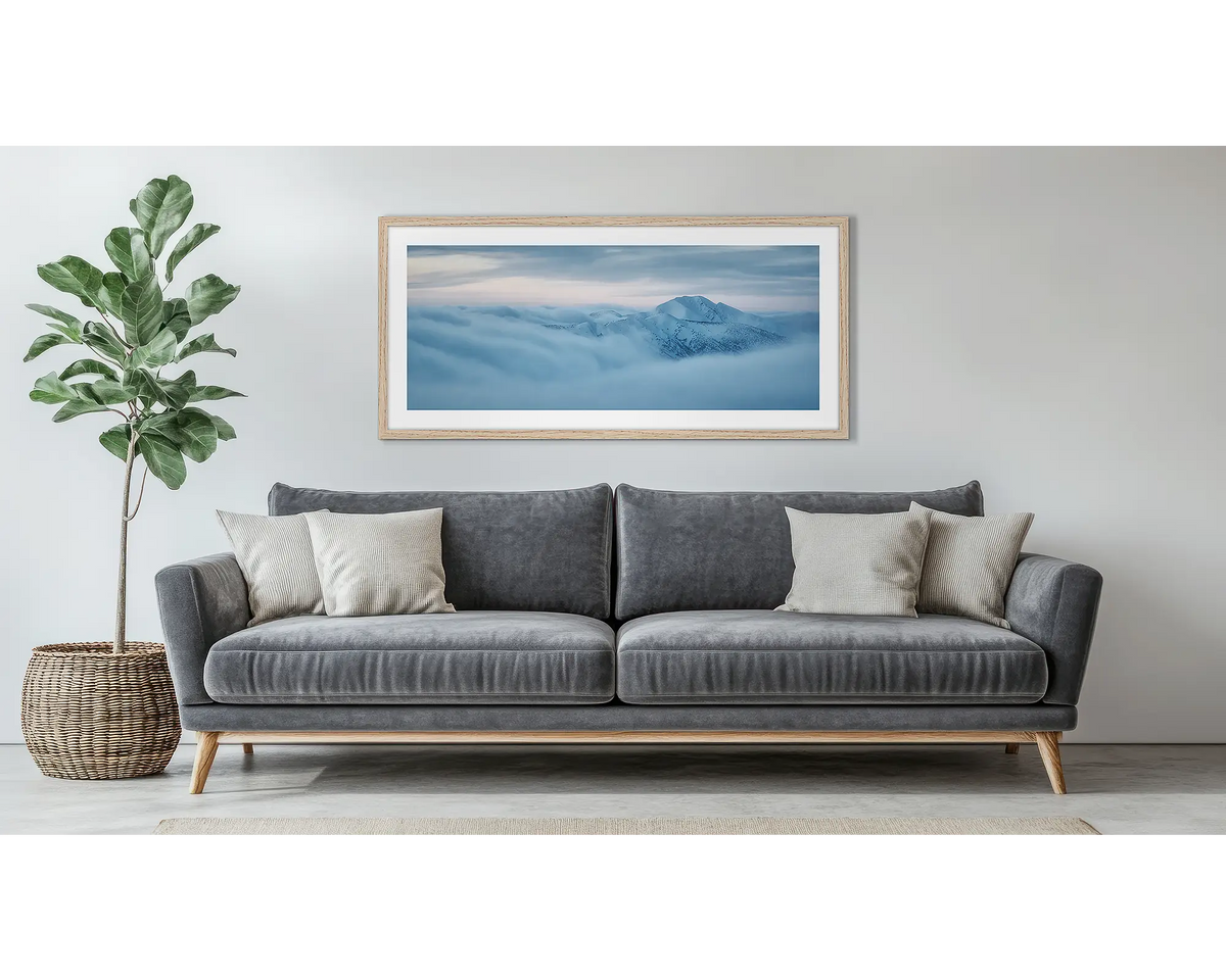 Above it All. Framed Mount Feathertop wall art print, with a timber frame, hung above a couch. 