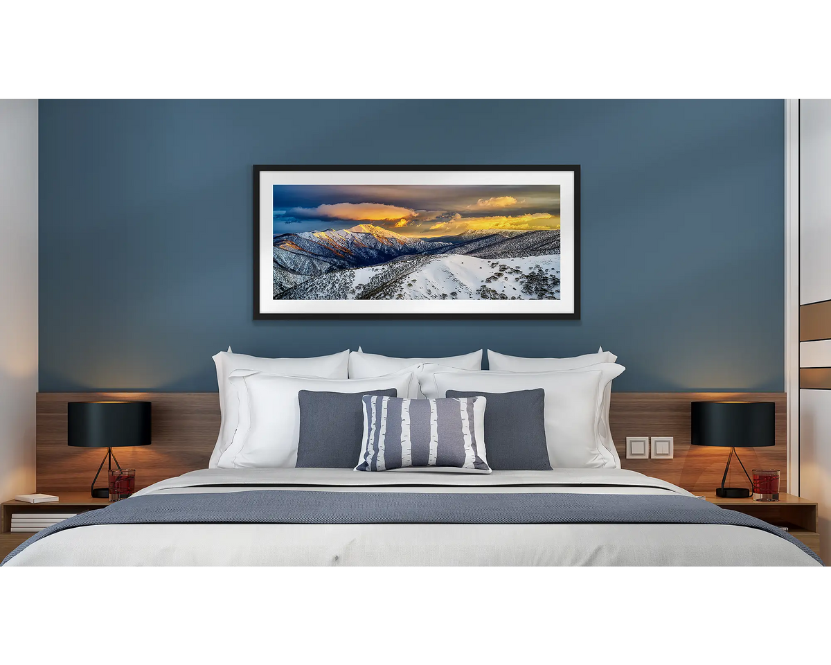 Alpine Magic. Snow sunrise wall art, framed in a black frame, hanging in a hotel room.