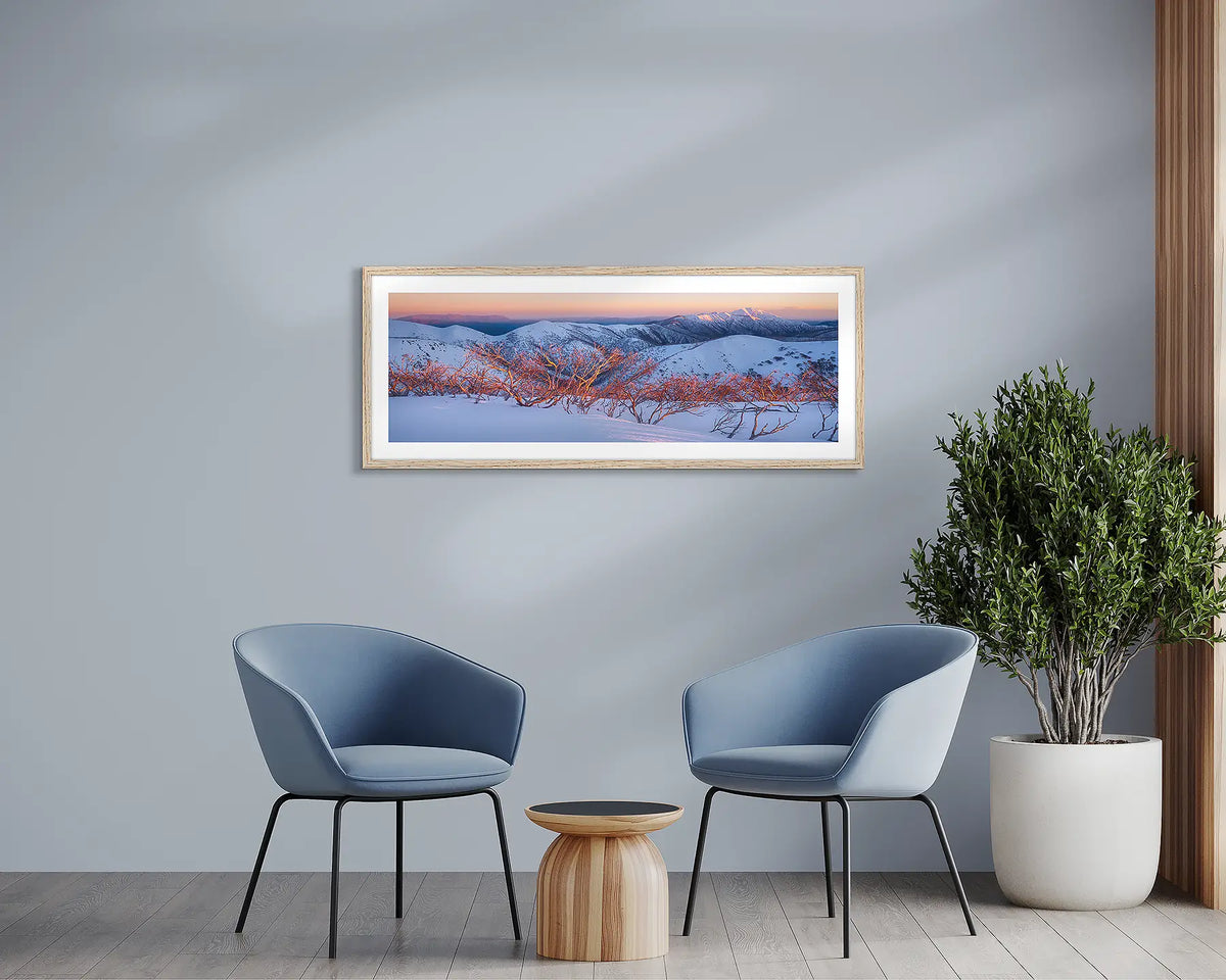 Alpine Sunrise. Winter snow wall art, with a timber frame, in a waiting room. 