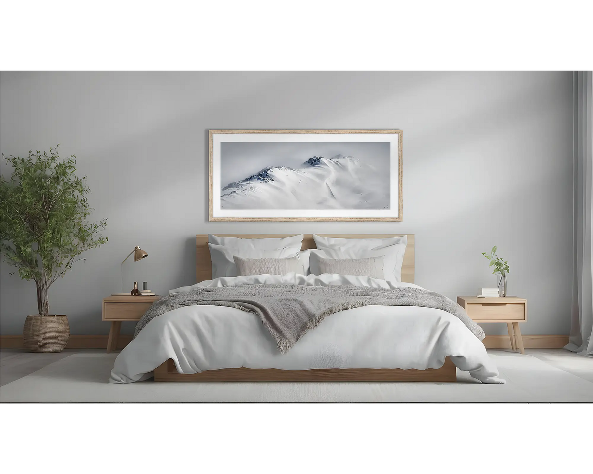 Ascent. Winter snow artwork in a timber frame, above a bed. 