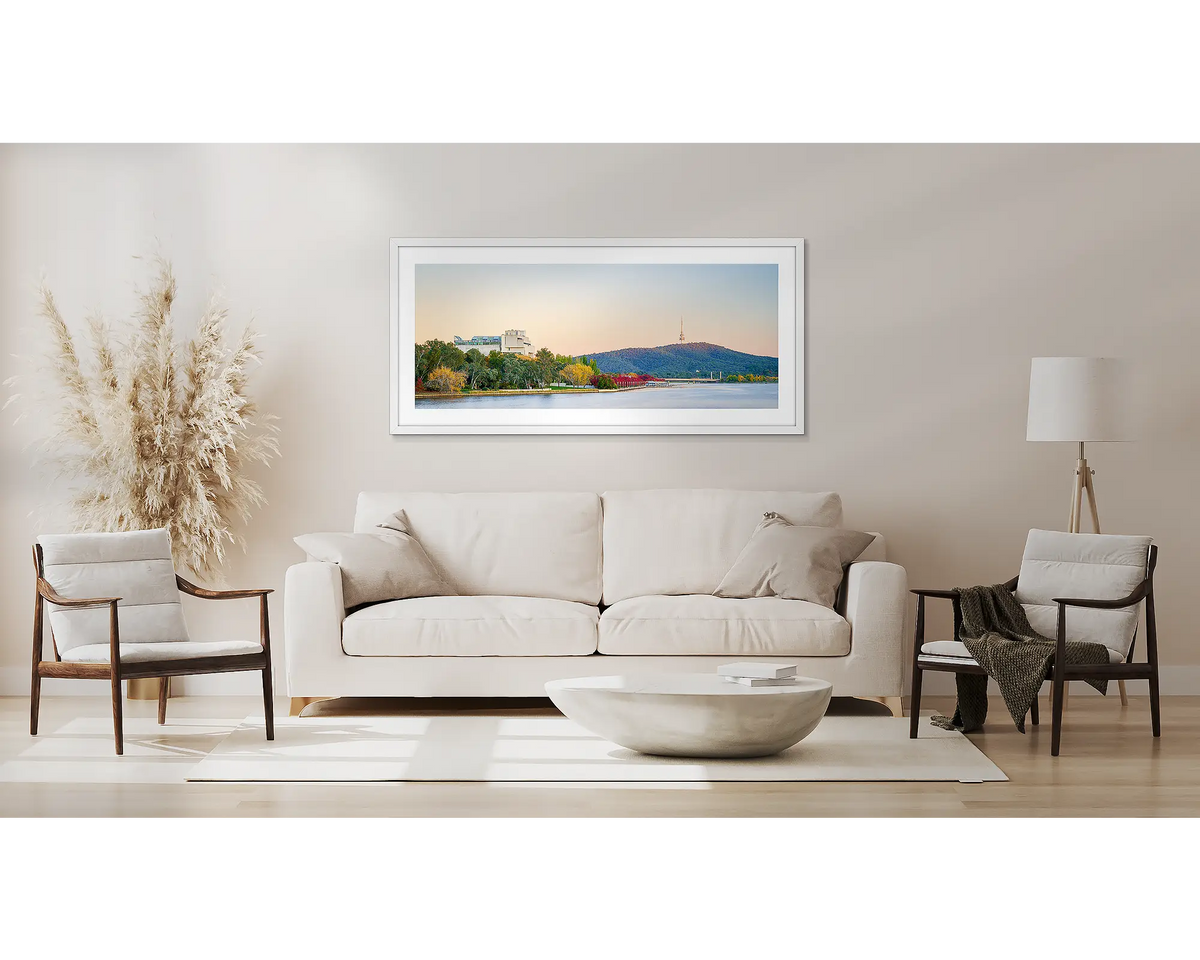 Autumn Arrival. Canberra sunrise wall art, with a white frame, above a couch. 