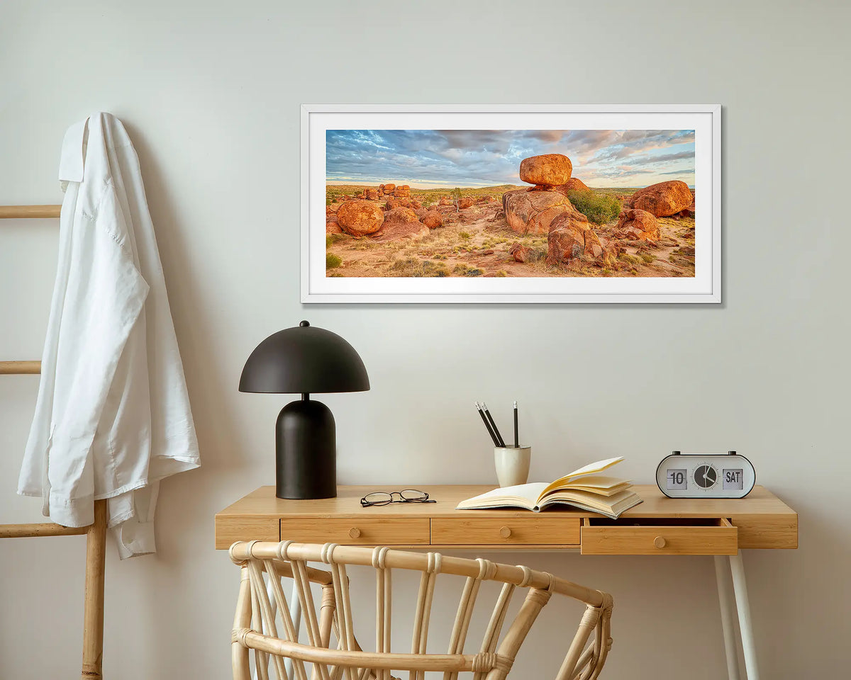 Balanced. Devils Marbles wall art print with white frame hung above small desk.