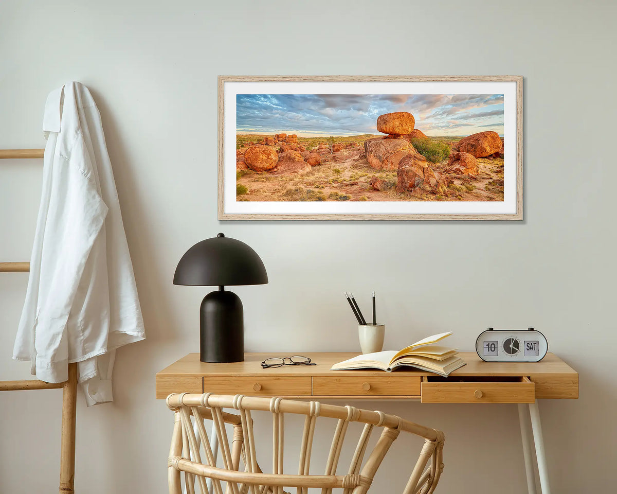 Balanced. Devils Marbles wall art print with wood frame hung above small desk.