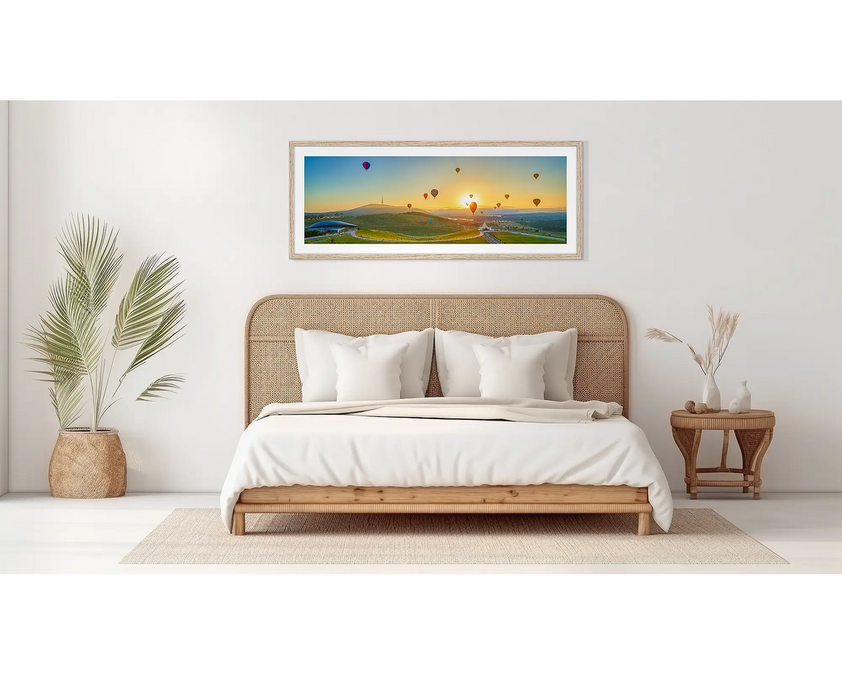 Balloon Sunrise. Wall art of balloons over the arboretum at sunrise, in an oak frame, in a bedroom. 