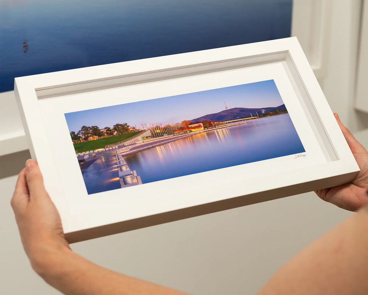 Before the Rush. Dawn over Lake Burley Griffin, Canberra. Small framed print with white frame being held.