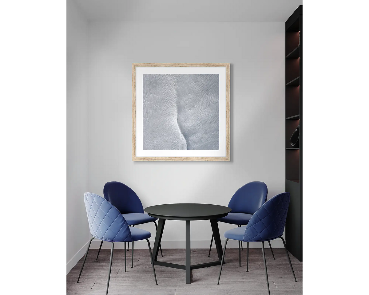 Beginning. Abstract snow, framed wall art print, with a timber frame, in an office meeting room. 