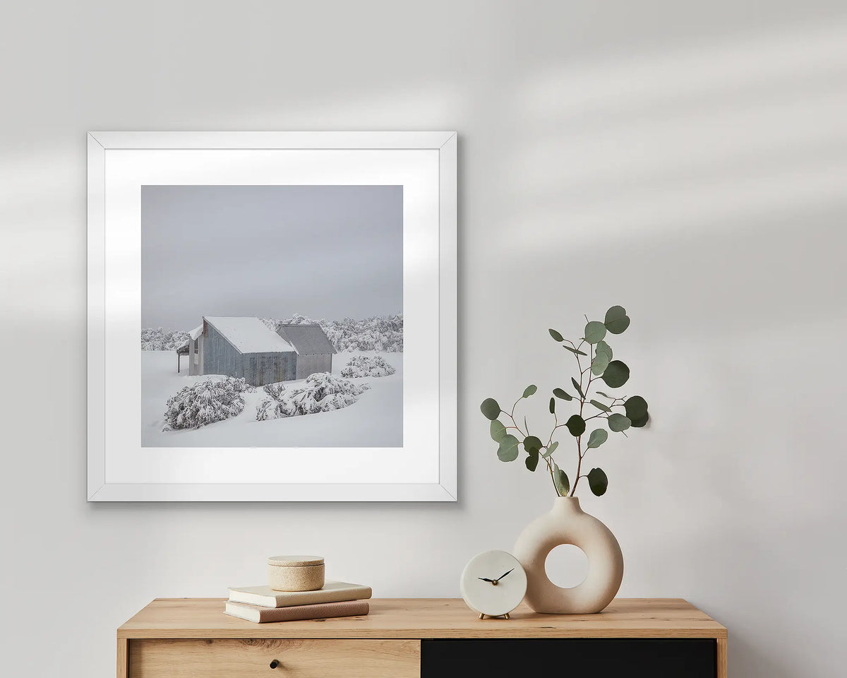 Blowhard. Snow artwork in a white frame above a Scandi table.