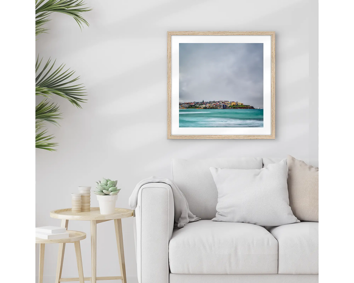 Bondi Views. Framed Sydney wall art print with a timber frame, hung above a couch. 