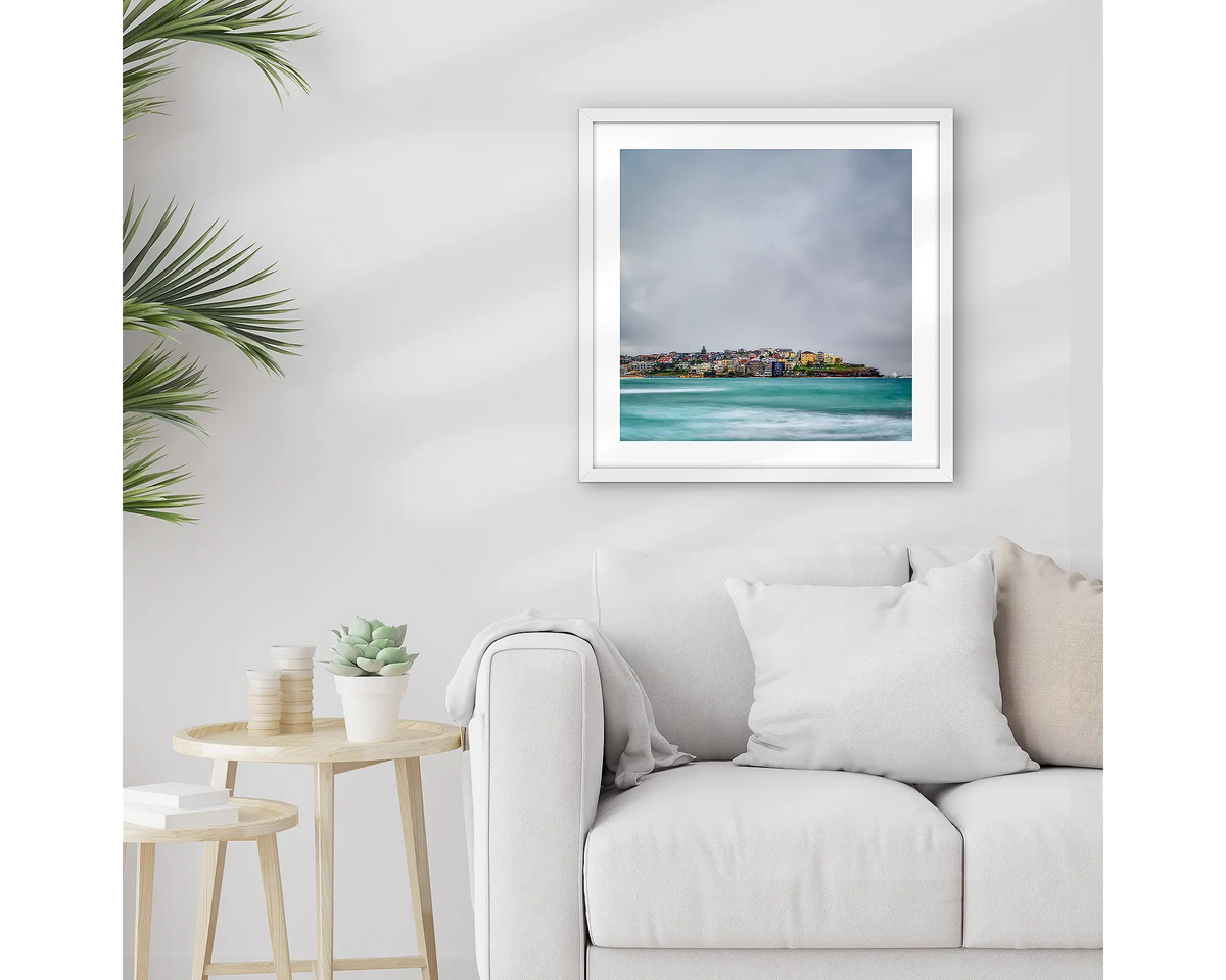 Bondi Views. Framed Sydney wall art print with a white frame, hung above a couch. 