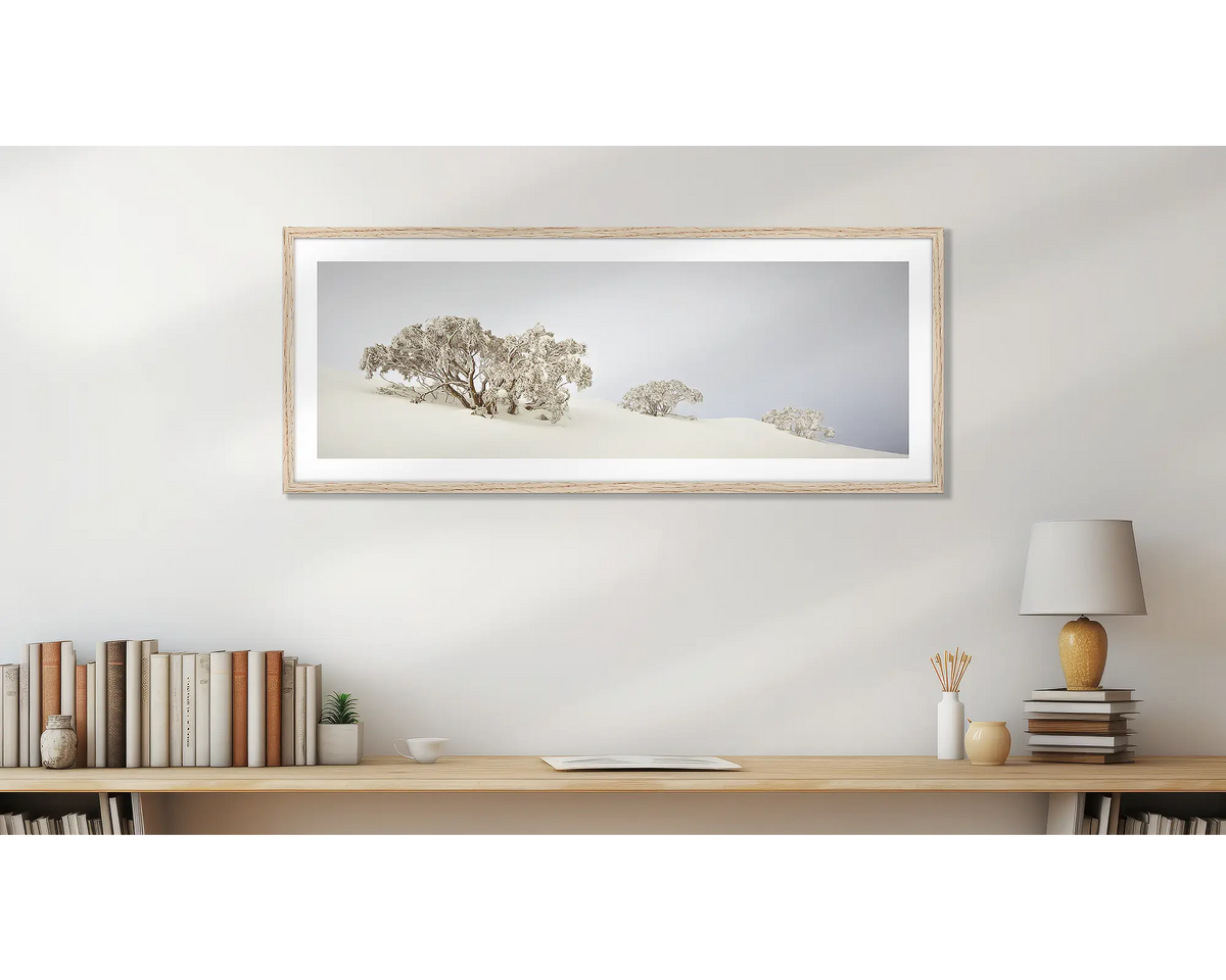 Braving The Elements Winter. Winter snow gums, wall art print, with a timber frame, above a desk. 