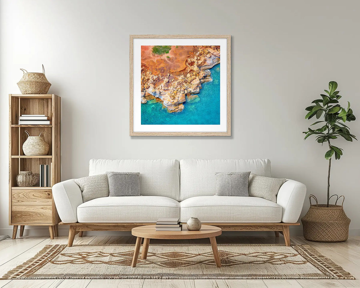 Broome Contrasts. Kimberley aerial wall art print, with a Tassie oak frame, above a couch. 