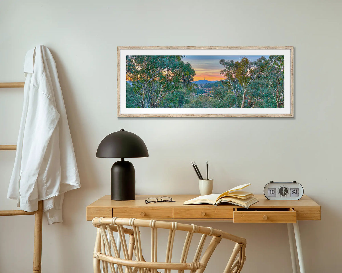 Bush Capital. Canberra wall art print with wood frame hung above small desk.