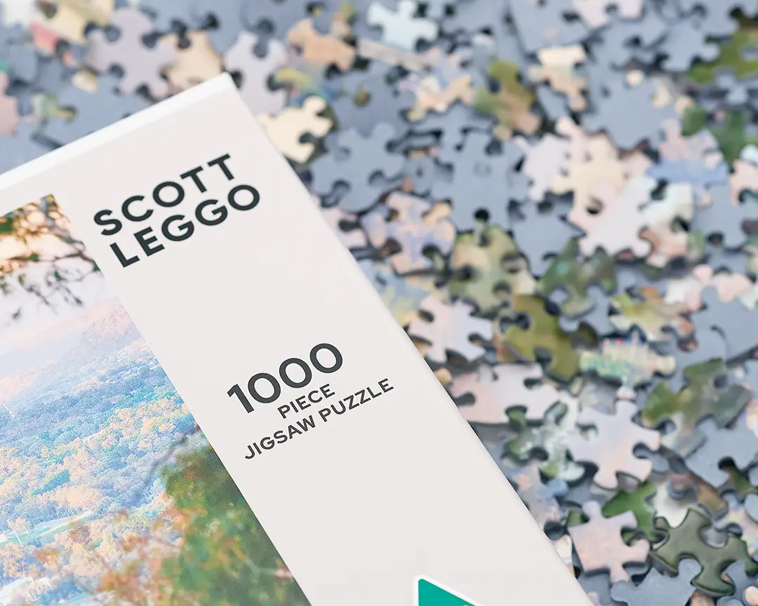 Scott Leggo 100 piece jigsaw puzzle box on top of pieces.