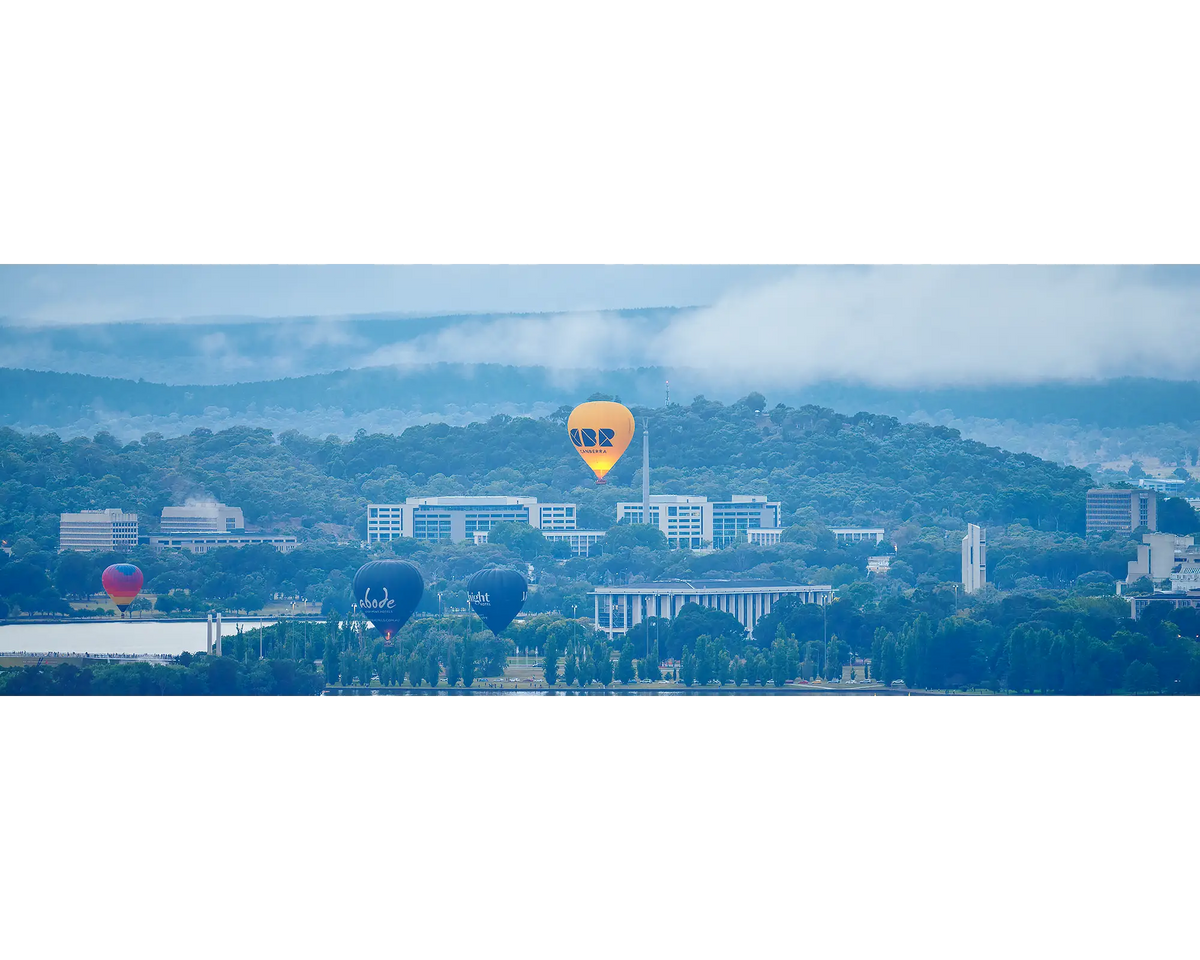 Canberra Rising - hot air balloons flying over Canberra landmarks with fog.