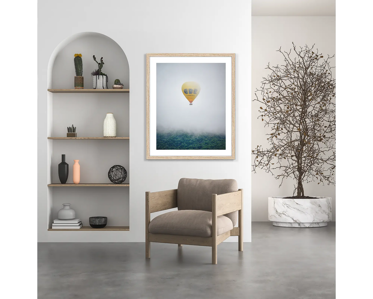 CBR Balloon. Visit Canberra wall art print, with a wood frame, hung above a chair.