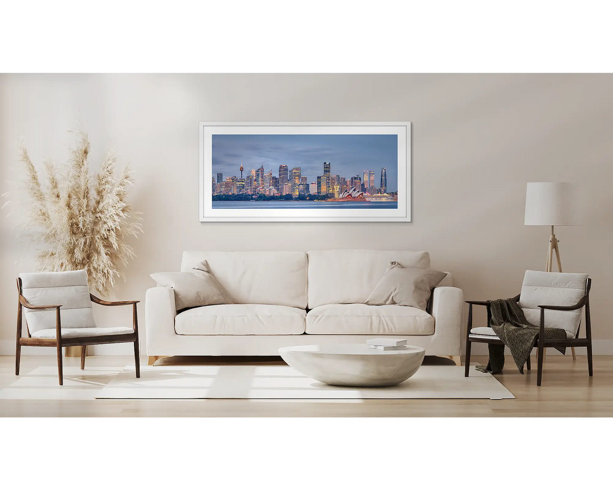 City Lights. Sydney wall art, with a white frame, above a couch. 