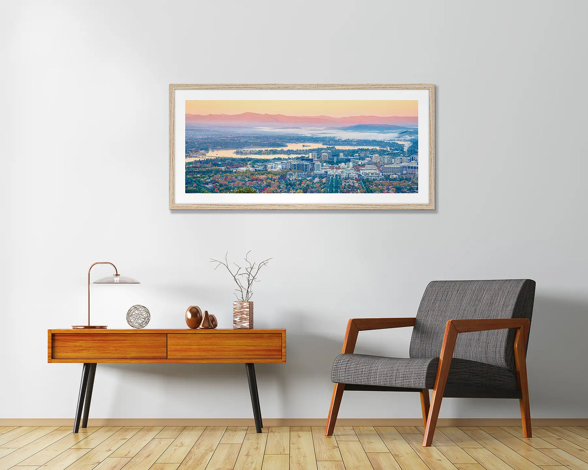 Civic Autumn. Canberra artwork fremd in Tasmanian Oak frame, hanging above a chair.