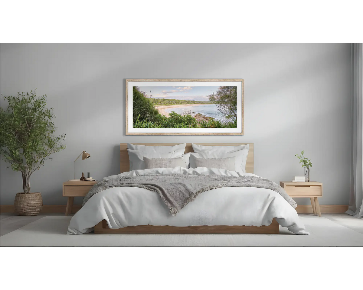 Coastal Retreat. South Coast wall art framed in a Tasmanian Oak frame, above a bed.