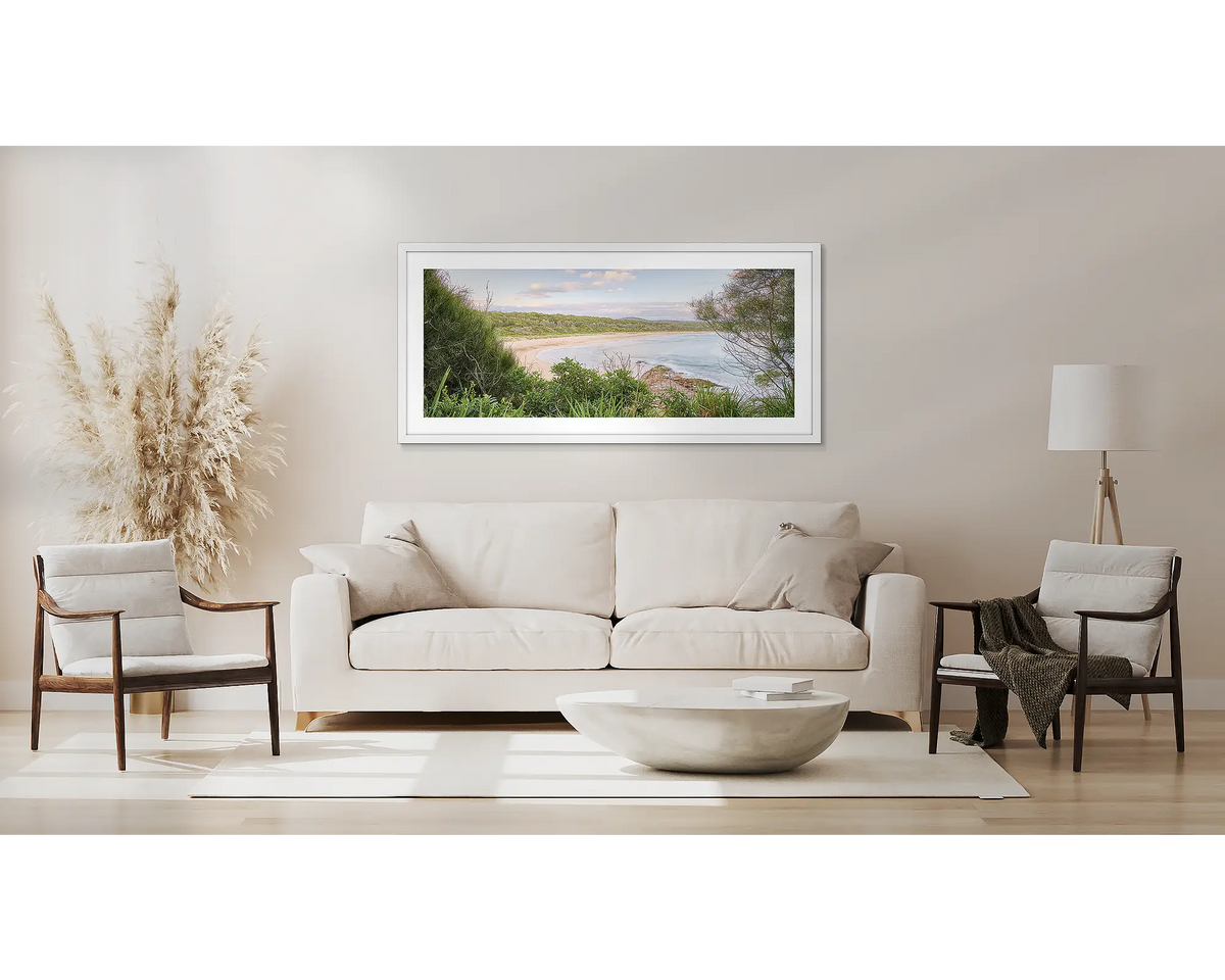 Coastal Retreat. South coast wall art, with a white frame, above a couch. 