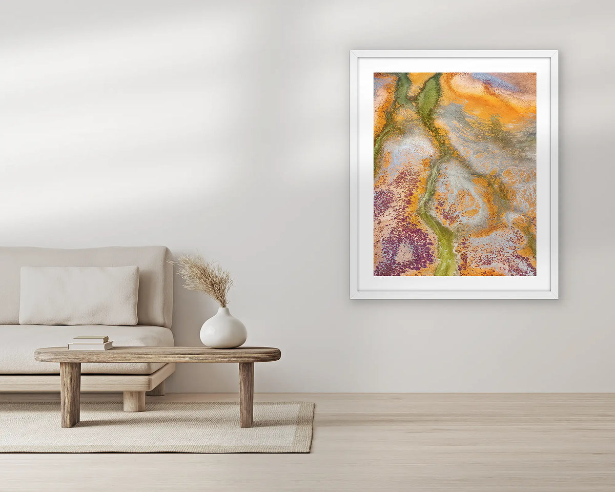 Collision. Abstract aerial wall art print, with a white frame, in a living room. 