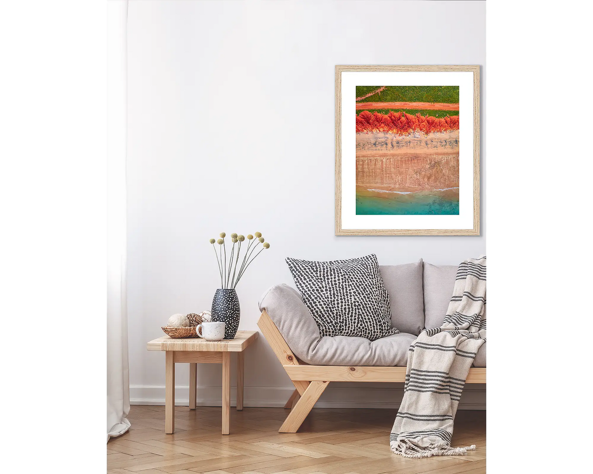 Coloured. Abstract Kimberley wall art print in a Tasmanian Oak frame, hanging above a couch.