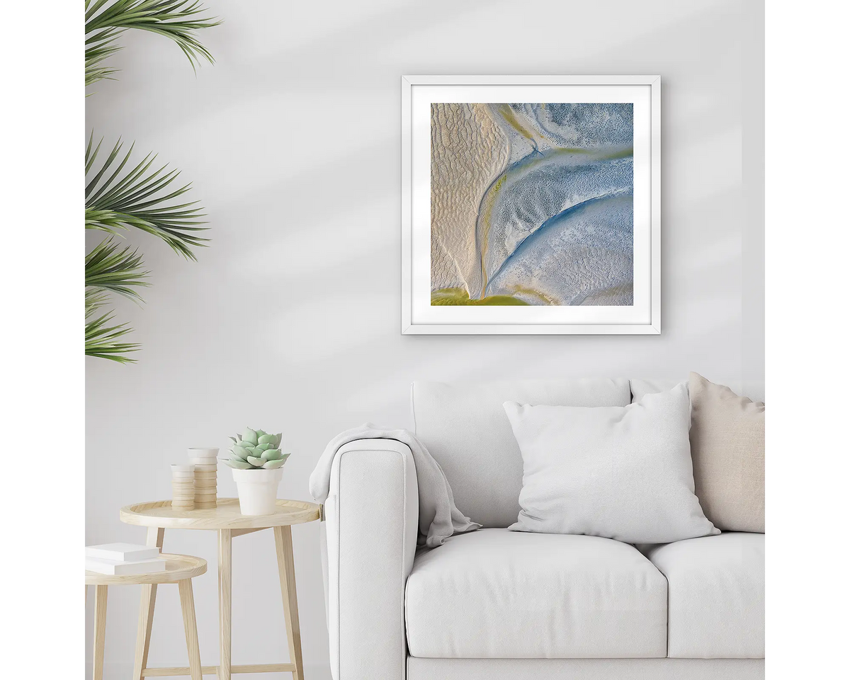 Complexion. Framed Kimberley wall art print, with a white frame, hung above a couch.