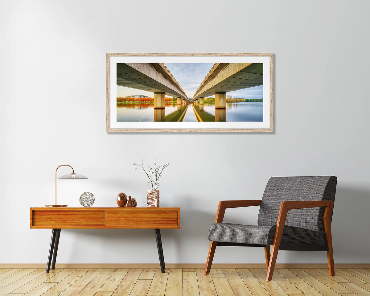 Convergent. Framed Canberra wall art, in a Tasmanian Oak frame, hanging above a chair.