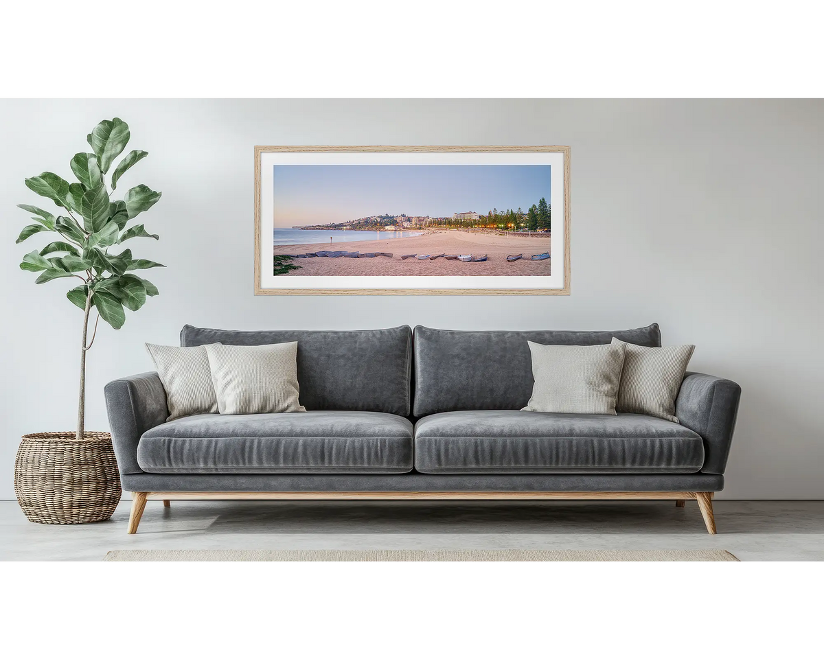 Coogee Sands. Framed wall art print of Coogee Beach in Sydney, with a timber frame, hung above a couch.