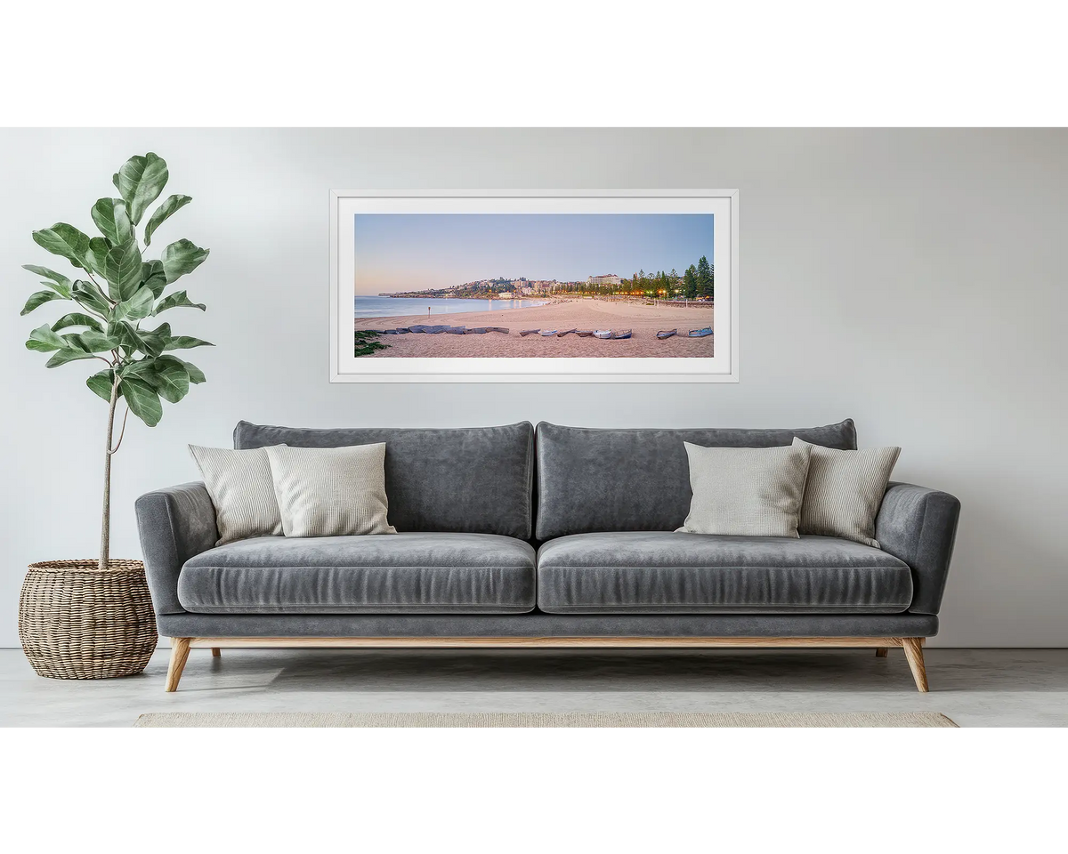 Coogee Sands. Framed wall art print of Coogee Beach in Sydney, with a white frame, hung above a couch.