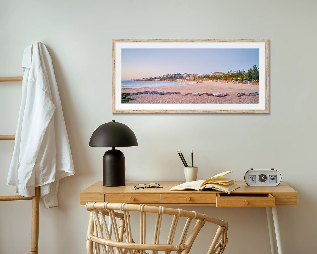 Coogee Sands. Sunrise at Coogee beach wall art print with wood frame hung above small desk.