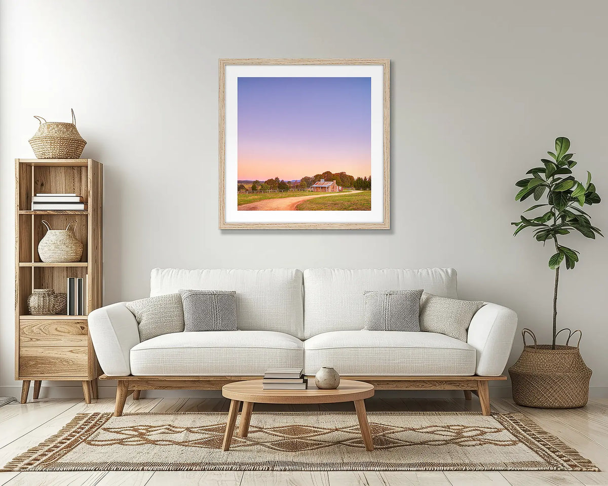 Country Charm. Rural farm wall art print, with a timber frame, above a couch. 