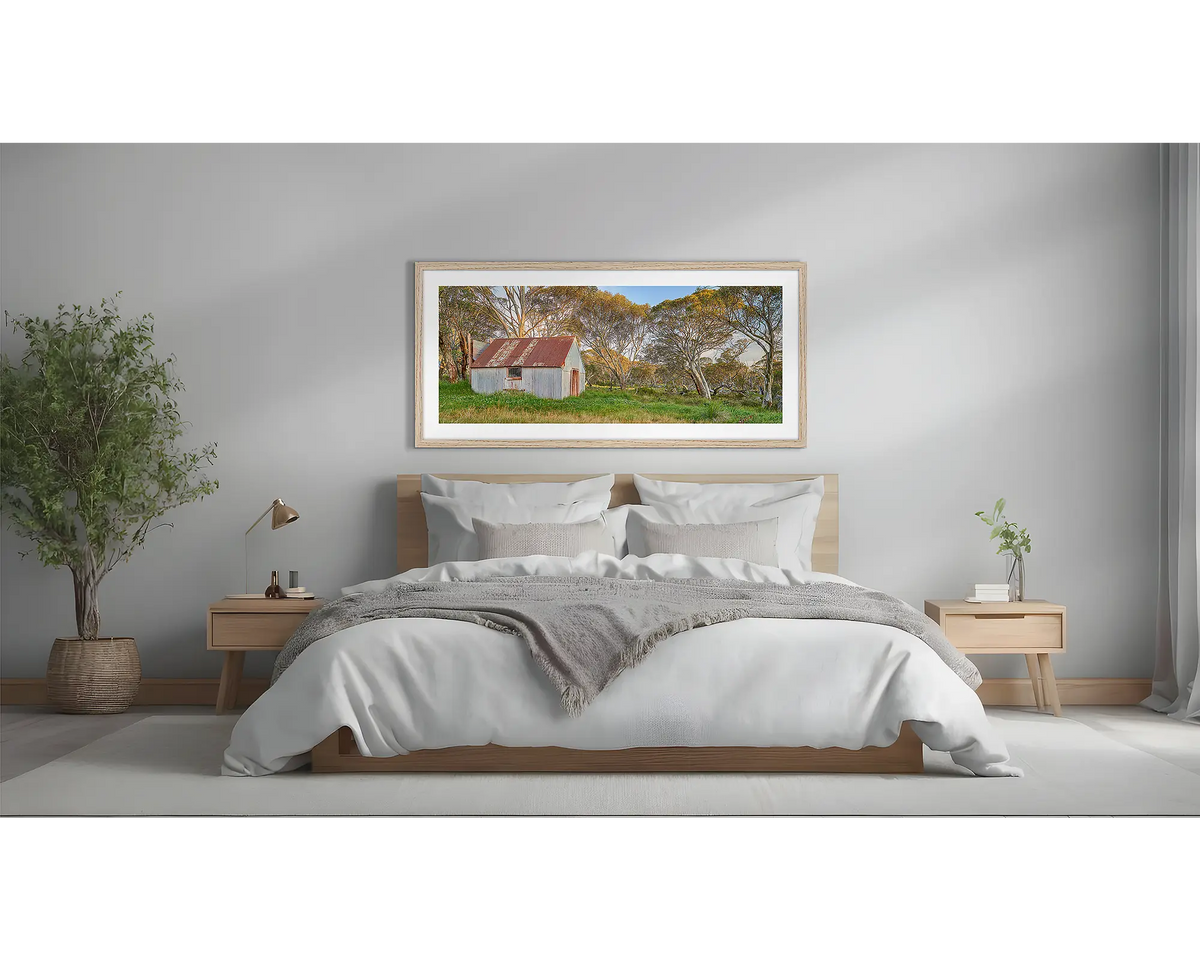 CRB Hut. High country wall art, framed in a Tasmanian Oak frame, hung above a bed.