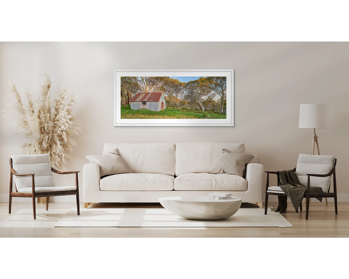 CRB Hut. High country wall art framed in white, hanging above a couch. 