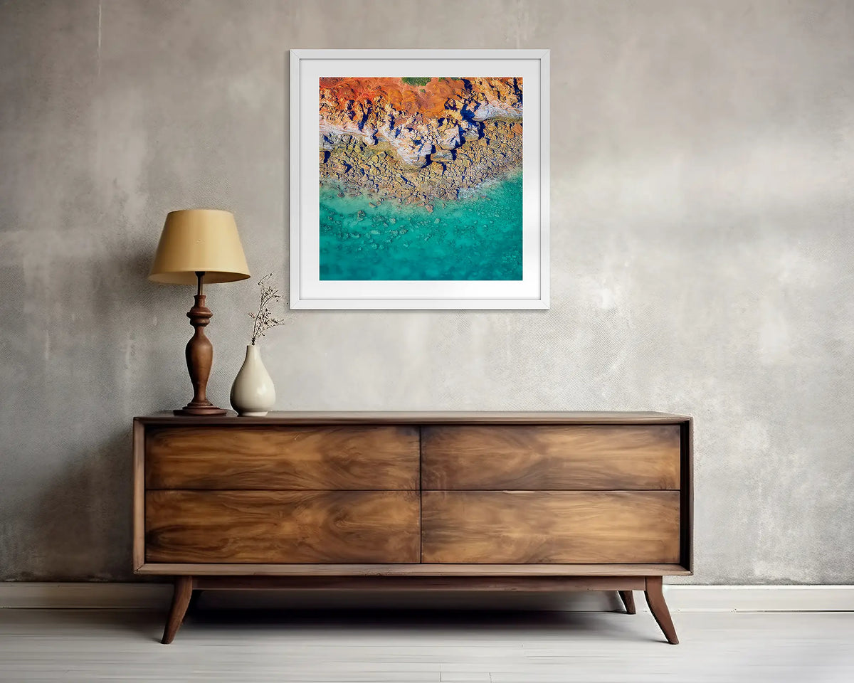 Dinosaur Land. Square, Broome wall art print, with a white frame, above a side table. 