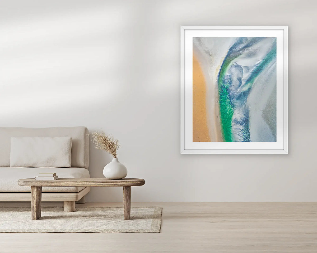 Displacement. Aerial wall art print, with a white frame, in a living room. 