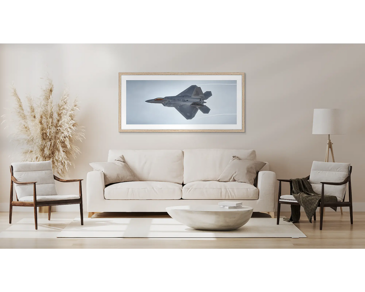 Dominating the Skies. F-22 Raptor aviation wall art print, with a Tasmanian Oak frame, above a couch. 