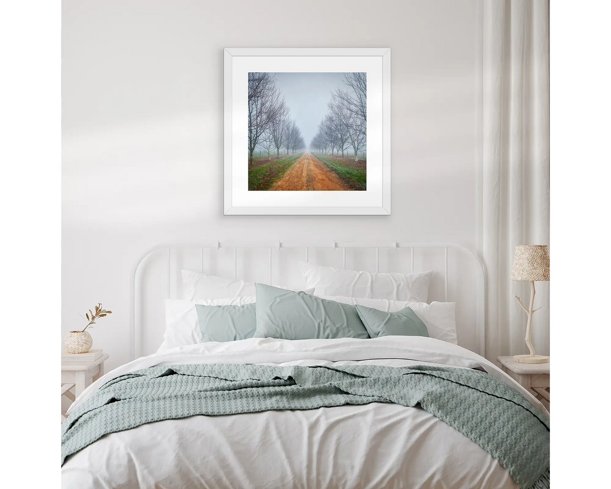 Down The Road. Artwork hanging above a bed, with white and gum leaf linen.