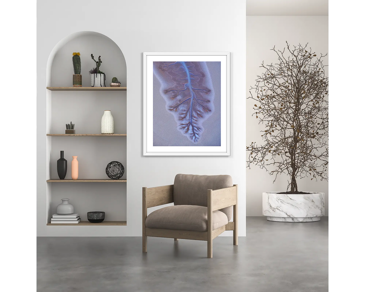 Downfall. Abstract Kimberley wall art print, with a white frame, hung above a chair.