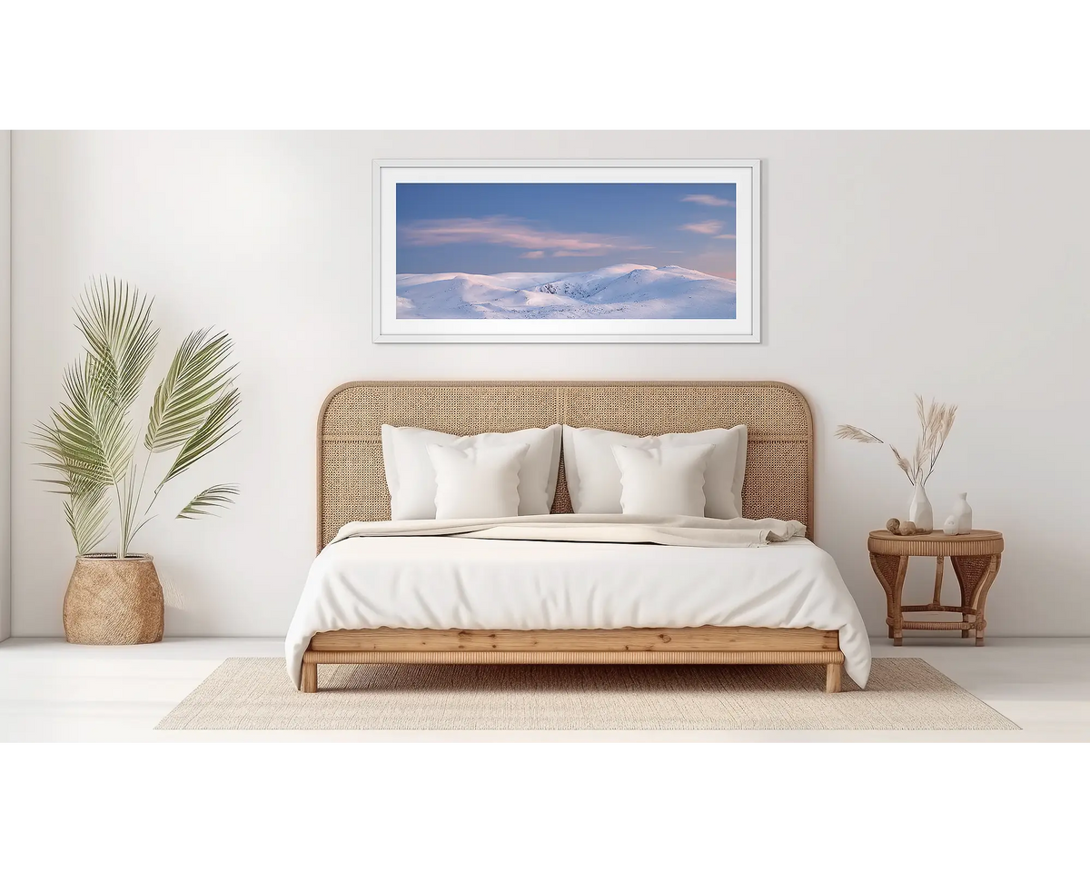 Early Morning. Snowy Mountains wall art in a white frame, in a bedroom. 