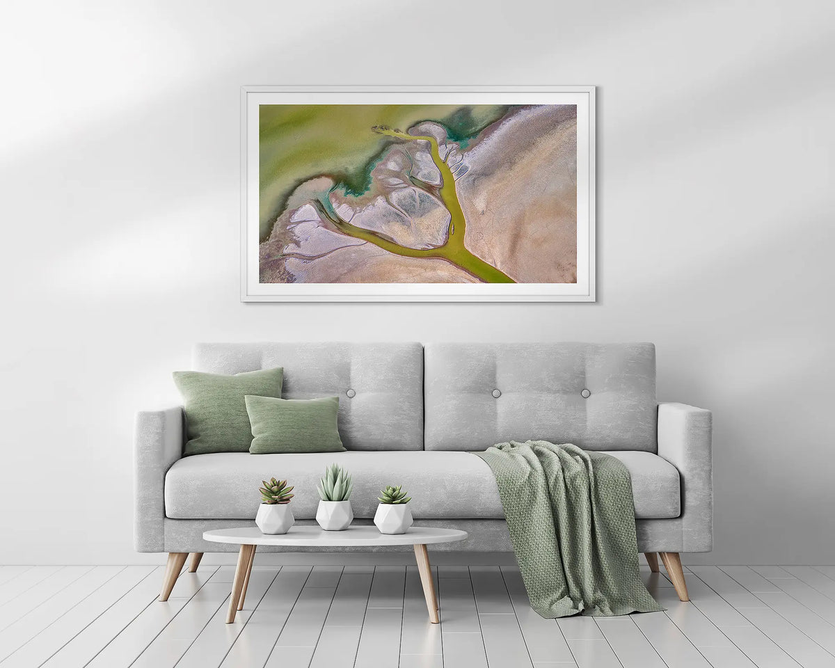 Embrace. Kimberley, abstract framed wall art print, with a white frame, above a couch. 