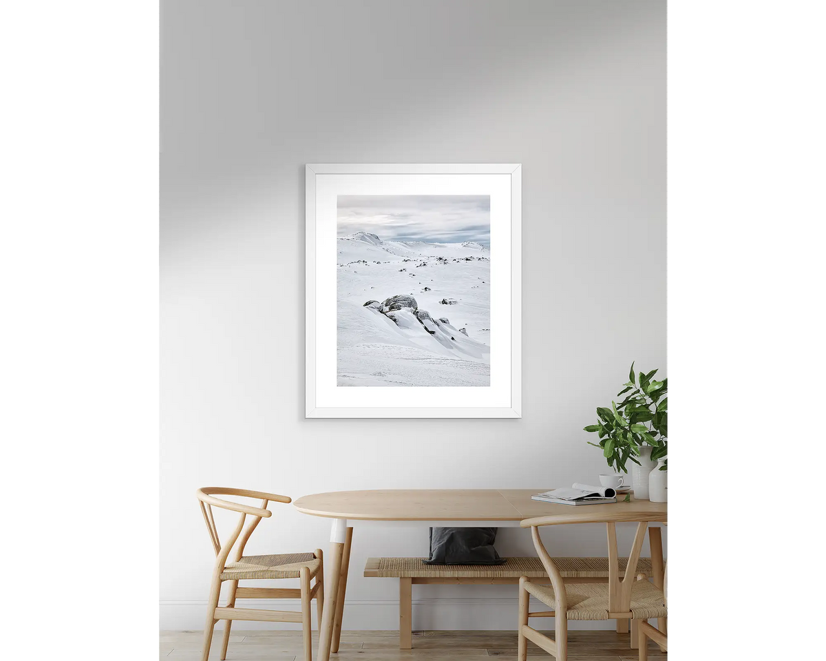 Etheridge Lines. Snow artwork with a white frame, above a table.