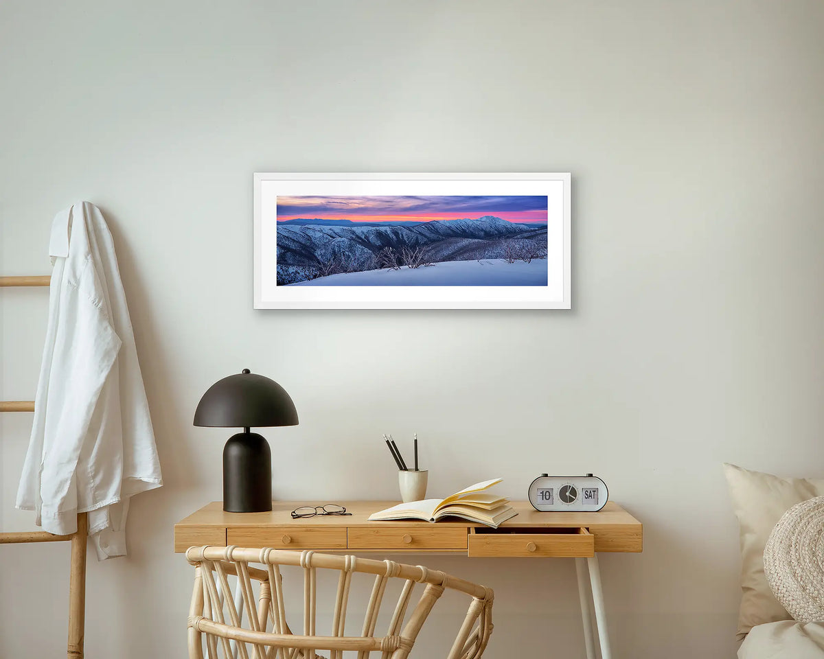 Evening Glory. Winter snow sunset photography, wall art with a white frame, above a bedside table. 