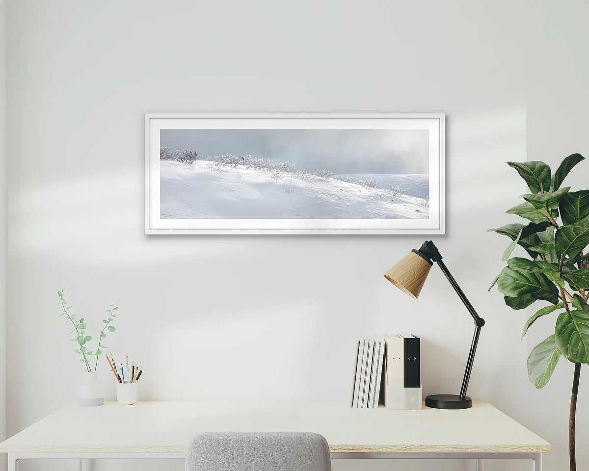 Exposed. Snow wall art print with white frame hung above home office desk.