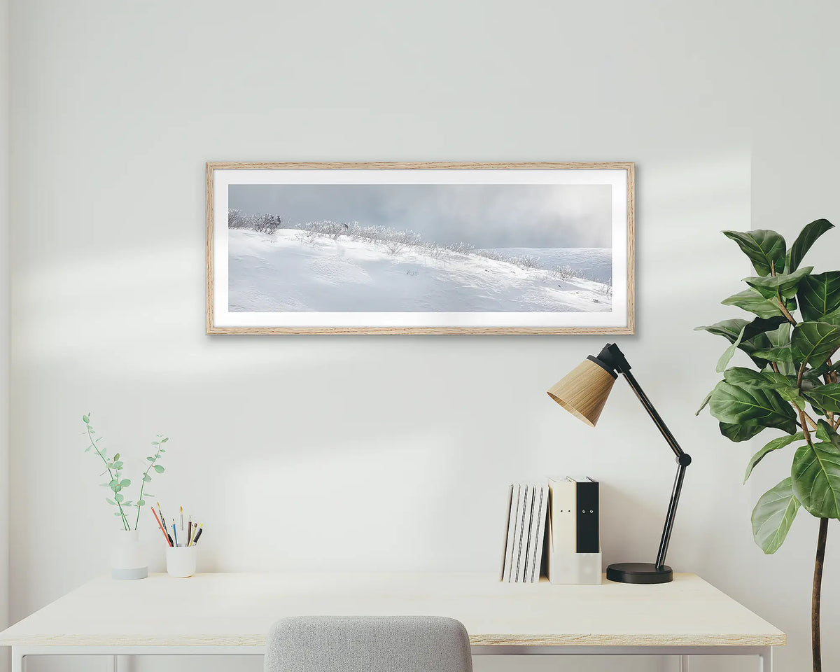 Exposed. Snow wall art print with wood frame hung above home office desk.