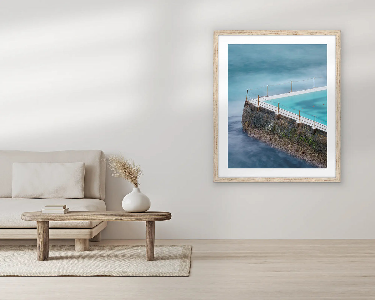 Fenced In. Bondi icebergs wall art print, with a Tassie oak frame, in a living room. 