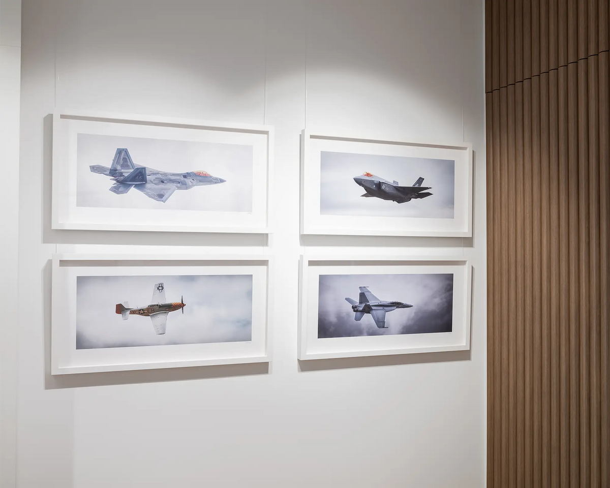 Fighting First. Aviation wall art, in a white frame, next to other aviation wall art prints. 