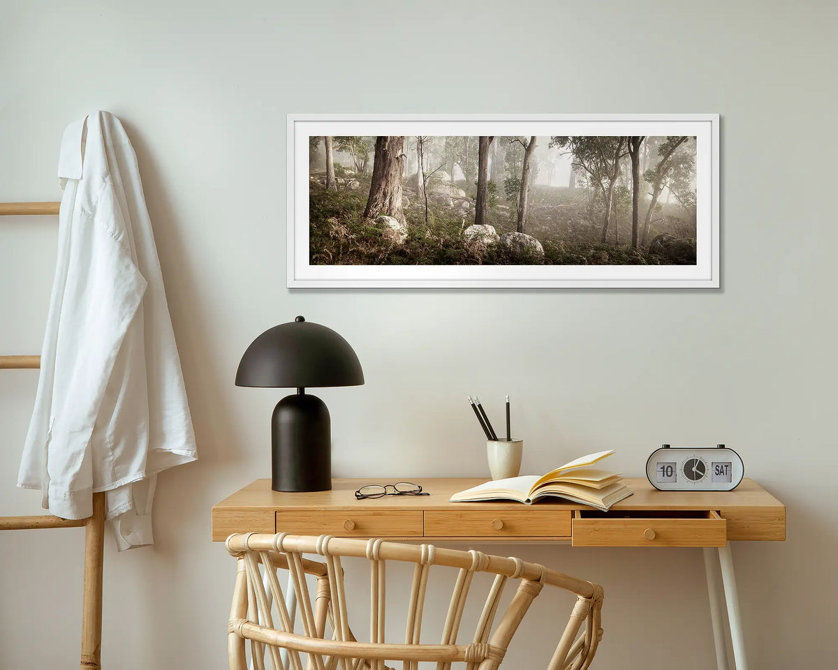 Forest in Fog. Mount Buffalo wall art print with white frame above small table.