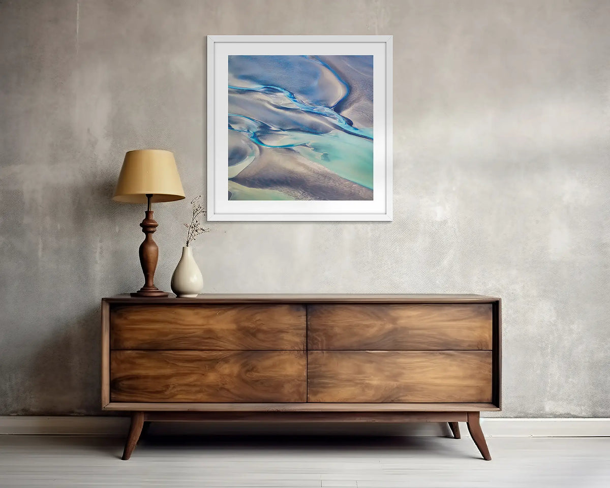 Formula. Abstract Kimberley wall art print, with a white frame, above a side table. 