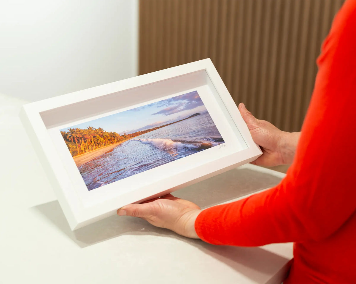 Four Mile Sunrise. Ocean waves and sunrise, small framed print, with a white frame. 