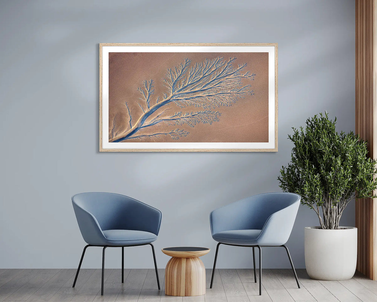 Groundwork. Abstract tidal patterns wall art print, with a white frame, hung above two chairs.